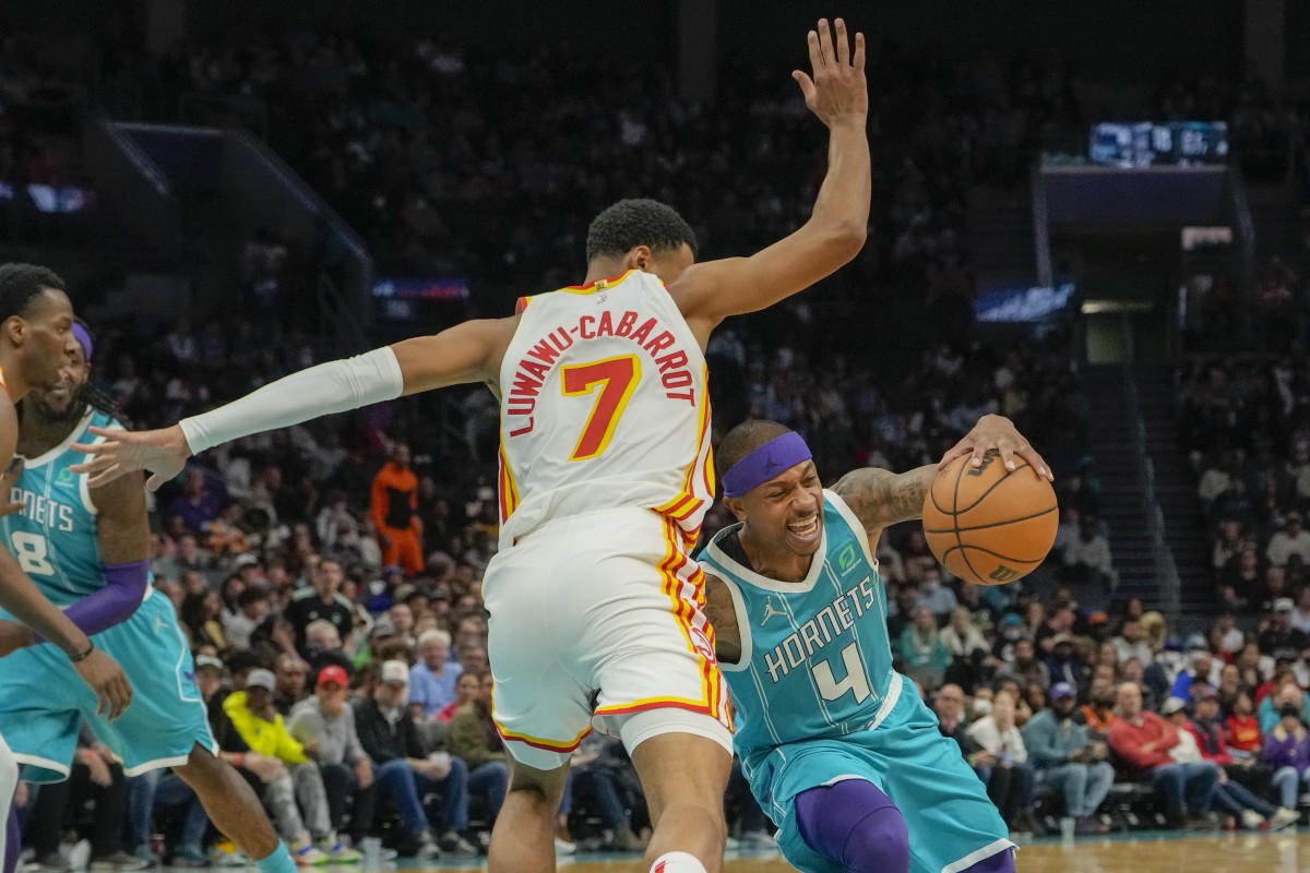 Mar 16, 2022; Charlotte, North Carolina, USA; Charlotte Hornets guard Isaiah Thomas (4) tries to corner around Atlanta Hawks guard Timothe Luwawu-Cabarrot (7) during the second half at the Spectrum Center.